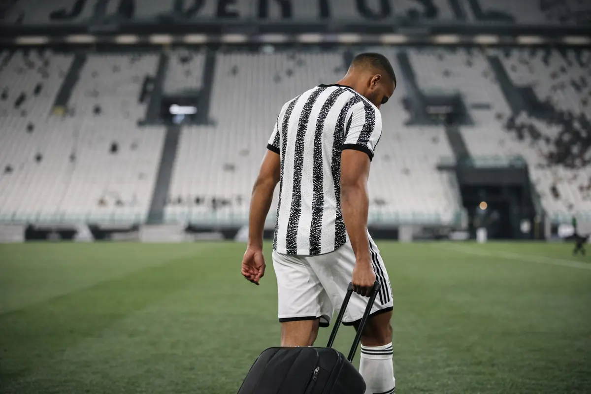 Bremer difensore della Juventus con la valigia in mano a testa bassa