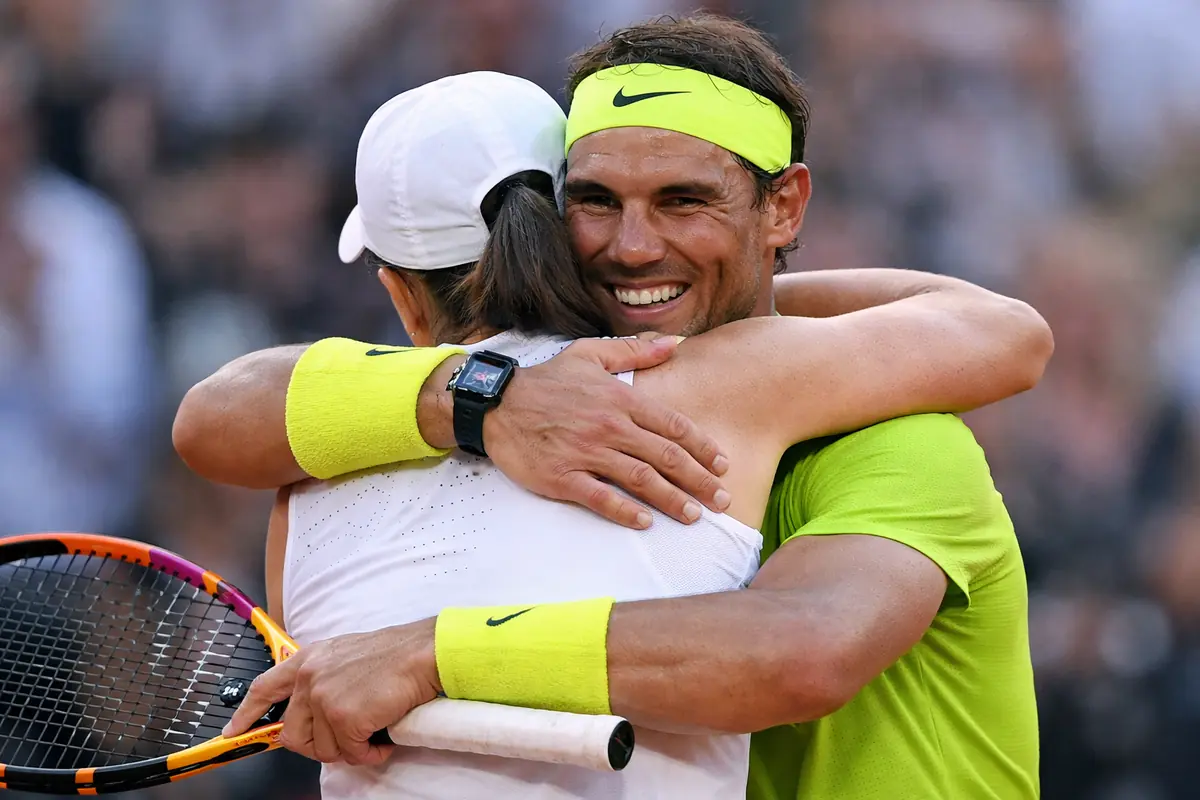 Nadal abbraccia una tennista di spalle dopo una partita