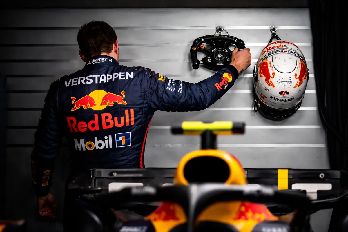 Verstappen mentre appende il volante al chiodo insieme al casco con la tuta Red Bull